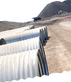 Mining Photo Stock Library - large water pipes ready for installation on open cut mine site with dump truck on haul road behind. ( Weight: 3  New Image: NO)