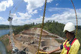 Mining Photo Stock Library - dogman worker in crane box with dam wall building construction below. ( Weight: 2  New Image: NO)