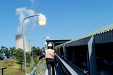 Mining Photo Stock Library - mine worker on walkway next to covered coal conveyor with cooling towers from power station in background. shot from behind. ( Weight: 3  New Image: NO)