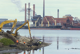 Mining Photo Stock Library - long arm reach excavator working on edge of port with workers supervising. ship terminal and wharf in background. ( Weight: 4  New Image: NO)