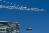 Mining Photo Stock Library - worker in a dog box being lifted by crane high up to a building. very clean shot with lots of sky for text. ( Weight: 2  New Image: NO)