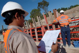 Mining Photo Stock Library - site supervisor in hard hat with clipboard of plans checks over site workers. ( Weight: 3  New Image: NO)
