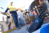 Mining Photo Stock Library - radio walkie talkie up close with worker out of focus in background. iniden signage can be removed. ( Weight: 2  New Image: NO)