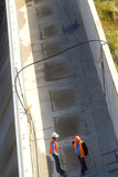 Mining Photo Stock Library - two workers in discussion on top of a dam wall. aerial vertical shot. ( Weight: 3  New Image: NO)