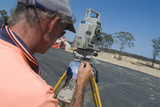 Mining Photo Stock Library - surveyor in ppe safety gear working on infrastructure road.  shot over his shoulder with great view of survey equipment. ( Weight: 1  New Image: NO)