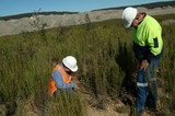 Mining Photo Stock Library - two mine environmental workers checking on revegetation areas with dragline and open cut coal mine in background. ( Weight: 2  New Image: NO)