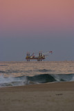 Mining Photo Stock Library - offshore drill rig getting ready to drill. fabulous sky colours with lots of sky in the shot.  shot with the beach in foreground.  desalination plant. vertical image. ( Weight: 1  New Image: NO)