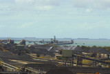 Mining Photo Stock Library - wide coal terminal shot with stockpiled coal and reclaimers and loaders and lots of ships waiting to be loaded in the background. ( Weight: 2  New Image: NO)