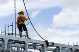 Mining Photo Stock Library - construtcion worker in full safety harness clipped into crane rigging and standing on top of bridge beam. ( Weight: 2  New Image: NO)