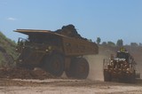 Mining Photo Stock Library - loaded haul truck with overburden moving on haul road with grader working in foreground. ( Weight: 3  New Image: NO)
