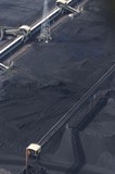 Mining Photo Stock Library - close up aerial photo of tractors stockpiling coal at shipping terminal.  conveyor working above to spread coal.  vertical image. ( Weight: 1  New Image: NO)