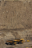 Mining Photo Stock Library - vertical photo 4 four haul trucks parked at go line in open cut coal mine.  worker in full PPE gives scale of machines.   ( Weight: 1  New Image: NO)