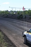 Mining Photo Stock Library - vertical photo of light vehicle with flag parked on graded haul access road.  great shot of good haul road.  coal stockpile conveyor in background. ( Weight: 1  New Image: NO)