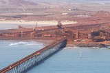 Mining Photo Stock Library - aerial photo of iron ore shipping terminal.  light vehicle driving on wharf for scale with ore conveyors and ore loaders in background.  set right on ocean. ( Weight: 1  New Image: NO)