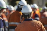 Mining Photo Stock Library - mine worker in full PPE at site meeting with lots of workers in background.  very generic shot with no faces and those in the background out of focus. ( Weight: 1  New Image: NO)