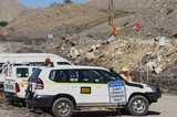 Mining Photo Stock Library - wide shot of light vehicles parked up at mine site.  worker in full PPE on radio or phone at front of the car.  all cars have flags and safety fit out.  also light vehicle signage. ( Weight: 1  New Image: NO)