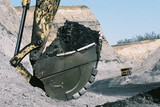 Mining Photo Stock Library - excavator bucket full of coal in foreground with haul truck returning down haul access road in background.  high walls of coal seam and open cut mine. ( Weight: 1  New Image: NO)