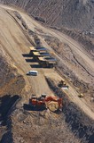 Mining Photo Stock Library - large excavator diggin overburden in open cut coal mine.  haul trucks parked up at go line in background.  aerial vertical image.  light vehicle mini bus transporting truck drivers in middle ground. ( Weight: 1  New Image: NO)