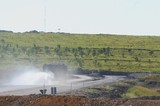 Mining Photo Stock Library - water cart spraying water on haul access road near workshop with mine site revegetation on hill in background. ( Weight: 1  New Image: NO)