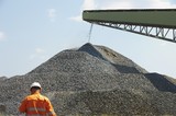 Mining Photo Stock Library - worker in full PPE with product being stockpiled in background. ( Weight: 1  New Image: NO)