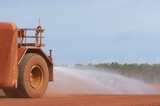 Mining Photo Stock Library - close up of water cart spraying mine access road for dust suppression. ( Weight: 1  New Image: NO)