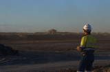 Mining Photo Stock Library - mine site worker in full PPE observing haul truck in late afernoon light in open cut mining site. ( Weight: 1  New Image: NO)