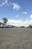 Mining Photo Stock Library - communications tower in the car park of remote mine site. light vehicles parked up.  generic photo showing site office buildings.  vertical format photo. ( Weight: 1  New Image: NO)