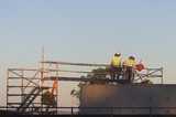 Mining Photo Stock Library - workers in full PPE heading into confined space from scaffolding.  shot at dawn and from a distance away. ( Weight: 1  New Image: NO)